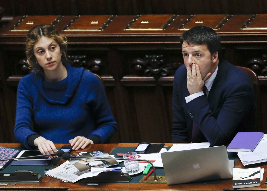 Italy's Prime Minister Matteo Renzi (R) sits next to Minister for Simplification of Public Administration Marianna Madia during a confidence vote at the lower house of the parliament in Rome February 25, 2014. Renzi won his first confidence vote in parliament, pledging to cut labour taxes, free up funds for investment in schools and pass wide institutional reforms to tackle Italy's economic malaise. Facing parliament for the first time, the 39-year-old Renzi who is Italy's youngest premier, sketched out an ambitious programme of change in an hour-long speech delivered in his trademark quickfire style interspersed with occasional jeers from the opposition benches. REUTERS/Giampiero Sposito (ITALY - Tags: POLITICS PROFILE BUSINESS)